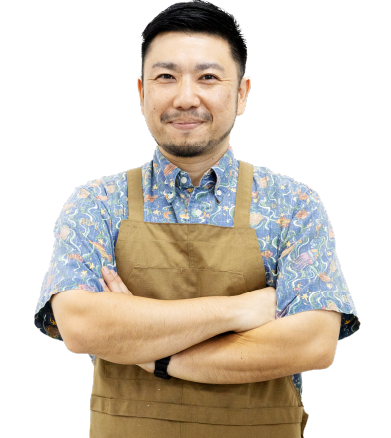 紅型工藝老師加治工攝手交叉微笑的照片